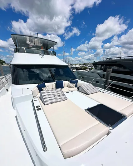  Yacht Photos Pics 2023 CL Yachts CLB65 luxury yacht with sunbathing area, docked under a vibrant blue sky.