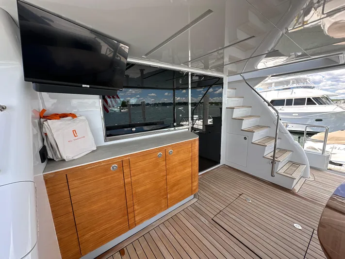  Yacht Photos Pics Luxurious 2023 CL Yachts CLB65 interior with wooden cabinetry and modern staircase.