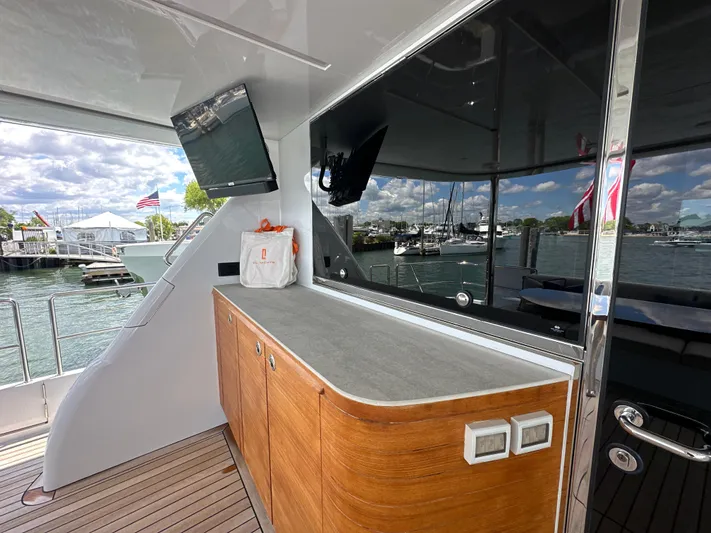  Yacht Photos Pics 2023 CL Yachts CLB65 yacht deck with wooden cabinetry and marina view.