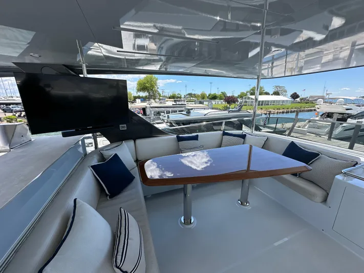  Yacht Photos Pics Luxurious 2023 CL Yachts CLB65 yacht deck with seating, table, and TV.