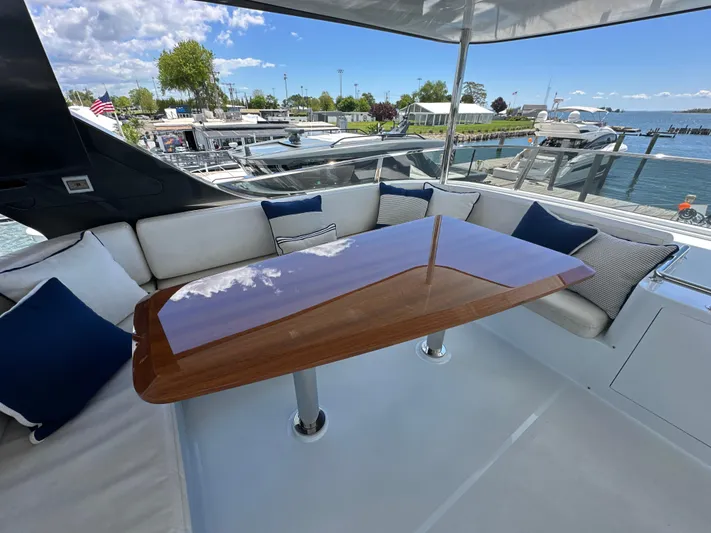  Yacht Photos Pics Luxurious seating area on 2023 CL Yachts CLB65 with elegant wooden table and waterfront view.