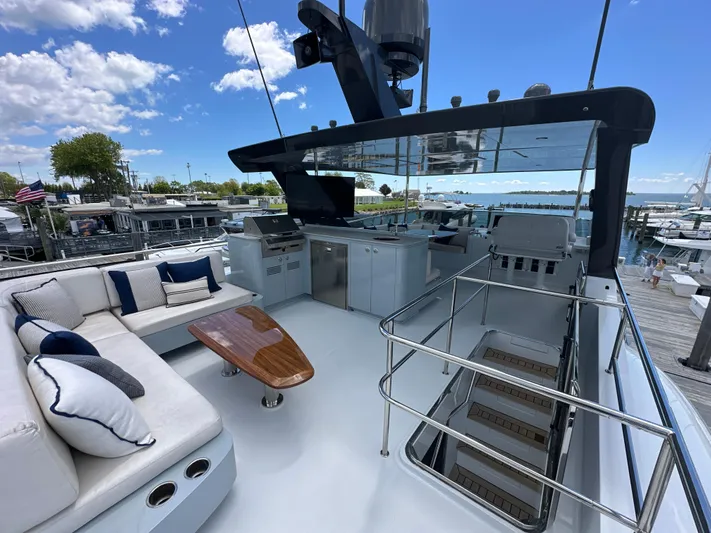 Yacht Photos Pics 2023 CL Yachts CLB65 yacht deck with seating, table, and marina view.