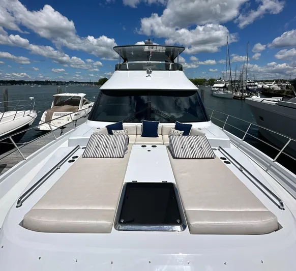  Yacht Photos Pics 2023 CL Yachts CLB65 luxury yacht with sun loungers, docked under a blue sky.