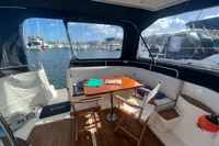 Interior of 1999 Nimbus 380 Carisma yacht with marina view, featuring seating and table.