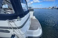 1999 Nimbus 380 Carisma yacht docked at marina, featuring sleek design and blue canopy.