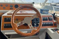 Steering wheel and dashboard of a 1999 Nimbus 380 Carisma boat, featuring wooden accents.