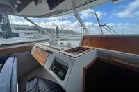 Interior view of 1999 Nimbus 380 Carisma boat cockpit with wooden accents and marina background.