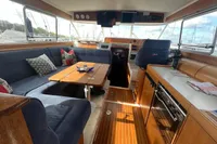 Interior of 1999 Nimbus 380 Carisma yacht with cozy seating and wooden finishes.
