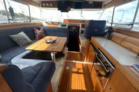 Interior of 1999 Nimbus 380 Carisma yacht with cozy seating and wooden finishes.