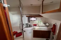 1999 Nimbus 380 Carisma yacht bathroom with sink, mirror, and red towels.