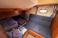 Cozy cabin interior of 1999 Nimbus 380 Carisma with blue upholstery and wooden accents.