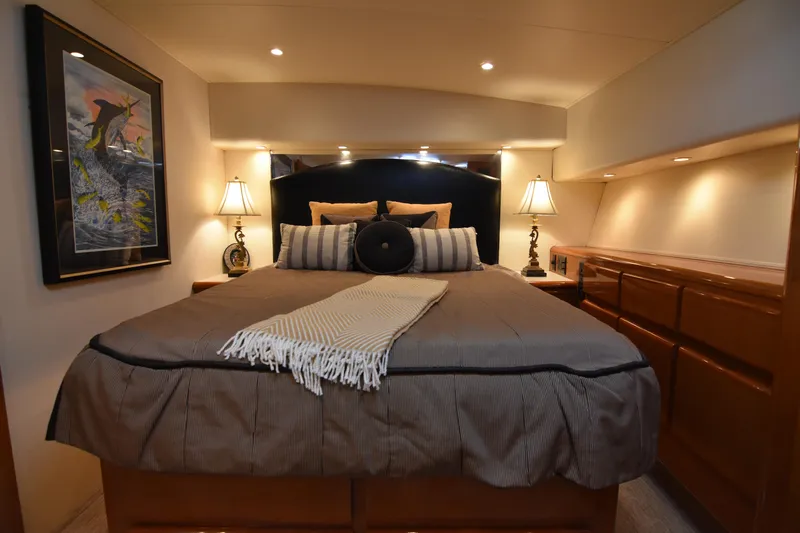 Legacy Yacht Photos Pics Luxurious bedroom interior of a 1999 Viking 58 Convertible yacht with elegant decor.