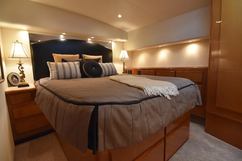 Legacy Yacht Photos Pics Luxurious bedroom interior of 1999 Viking 58 Convertible yacht with elegant lighting and decor.