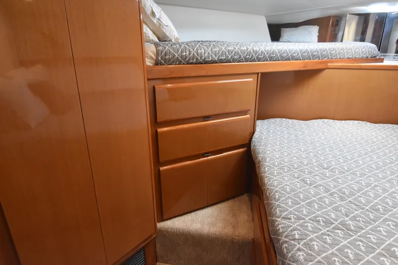Legacy Yacht Photos Pics 1999 Viking 58 Convertible yacht interior with wooden cabinetry and patterned bedding.