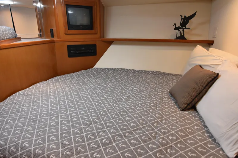 Legacy Yacht Photos Pics Cozy bedroom in 1999 Viking 58 Convertible yacht with TV and decorative sculpture.