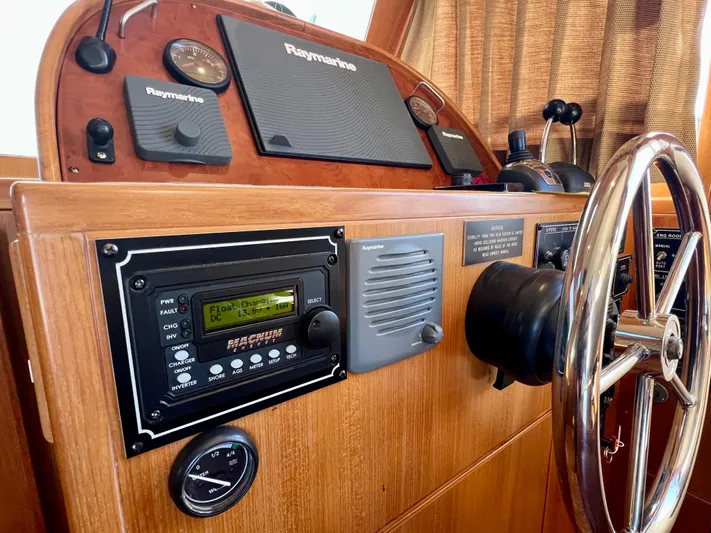  Yacht Photos Pics Helm of 2008 Island Pilot 435 with Raymarine navigation equipment and wooden steering wheel.