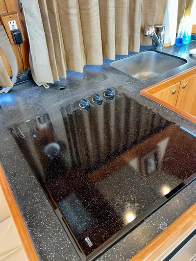  Yacht Photos Pics Modern kitchen countertop with black cooktop in 2008 Island Pilot 435 boat.