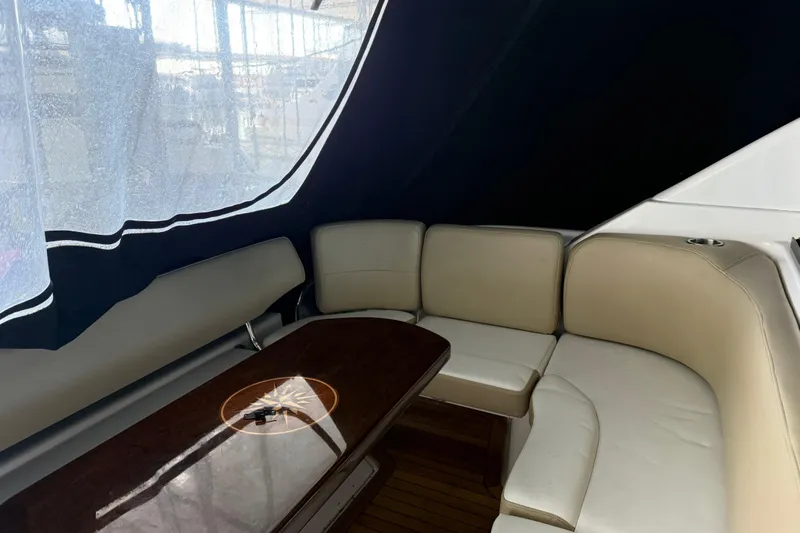  Yacht Photos Pics Luxurious interior of 2012 Regal 46 Sport Coupe with beige seating and wooden table.