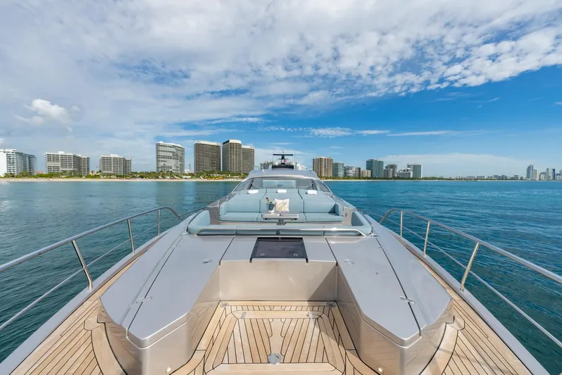 Vintage Yacht Photos Pics Luxurious 2021 Pershing 9X yacht cruising near a city skyline under a blue sky.