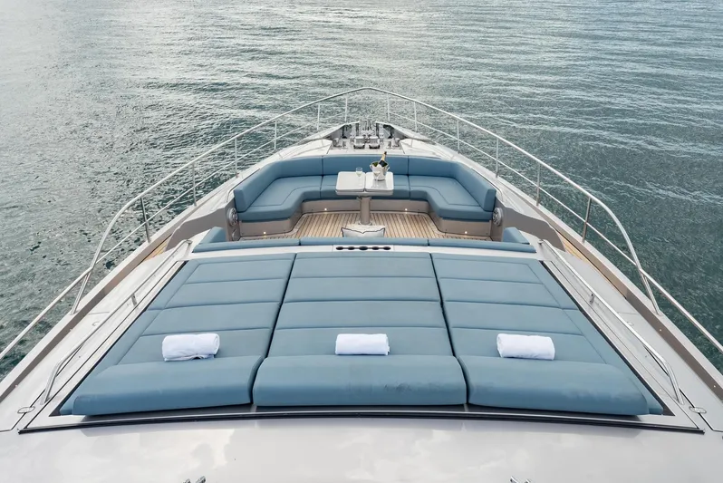 Vintage Yacht Photos Pics Luxury 2021 Pershing 9X yacht deck with sunbeds and seating area on calm water.