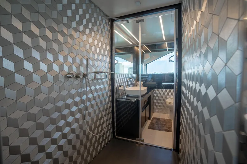 Vintage Yacht Photos Pics Luxurious bathroom in 2021 Pershing 9X yacht with geometric wall tiles and modern fixtures.