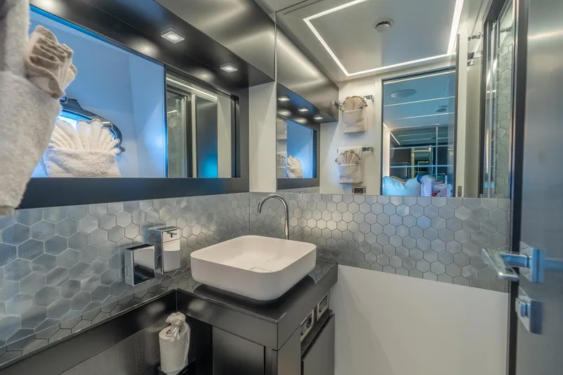 Vintage Yacht Photos Pics Luxurious bathroom in 2021 Pershing 9X yacht with modern fixtures and hexagonal tile design.