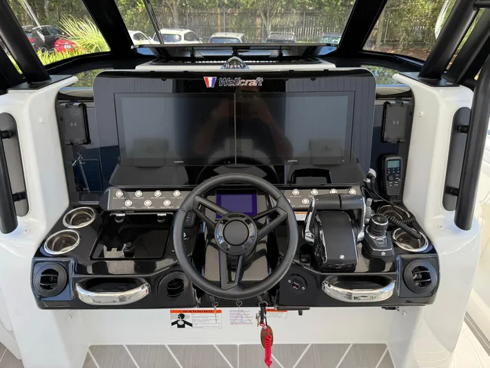  Yacht Photos Pics 2025 Wellcraft 38 T-Top boat dashboard with steering wheel and modern controls.