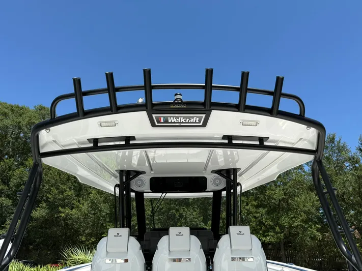 Yacht Photos Pics 2025 Wellcraft 38 T-Top boat with sleek design against clear blue sky.