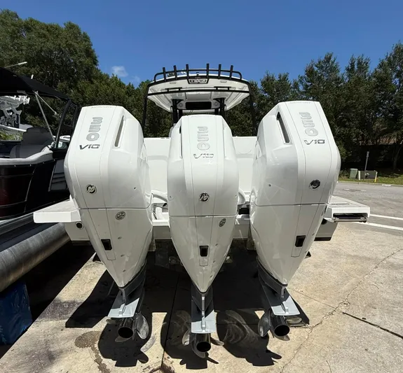  Yacht Photos Pics 2025 Wellcraft 38 T-Top boat with triple V10 engines, parked outdoors.