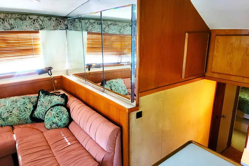 Trophy Hunter Yacht Photos Pics Interior of 1989 Bertram 50 Convertible yacht with pink sofa and tropical cushions.
