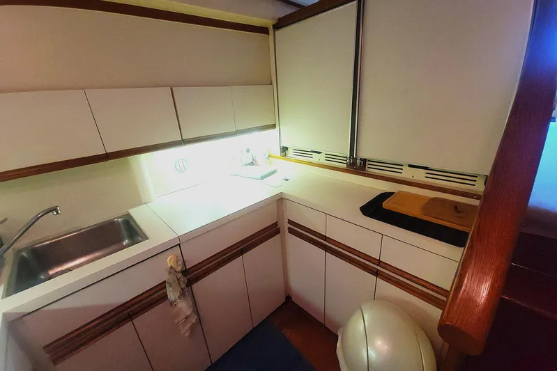 Trophy Hunter Yacht Photos Pics 1989 Bertram 50 Convertible yacht kitchen with sink, cabinets, and cutting board.