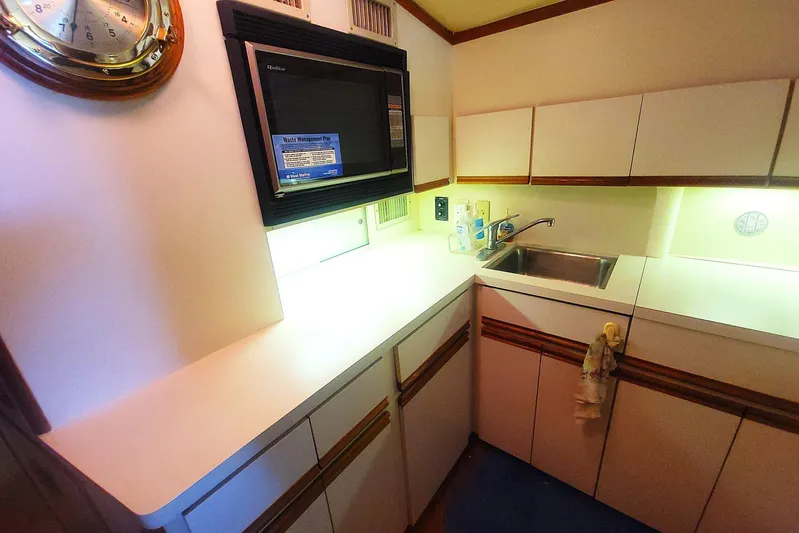 Trophy Hunter Yacht Photos Pics 1989 Bertram 50 Convertible yacht kitchen with microwave, sink, and cabinetry.