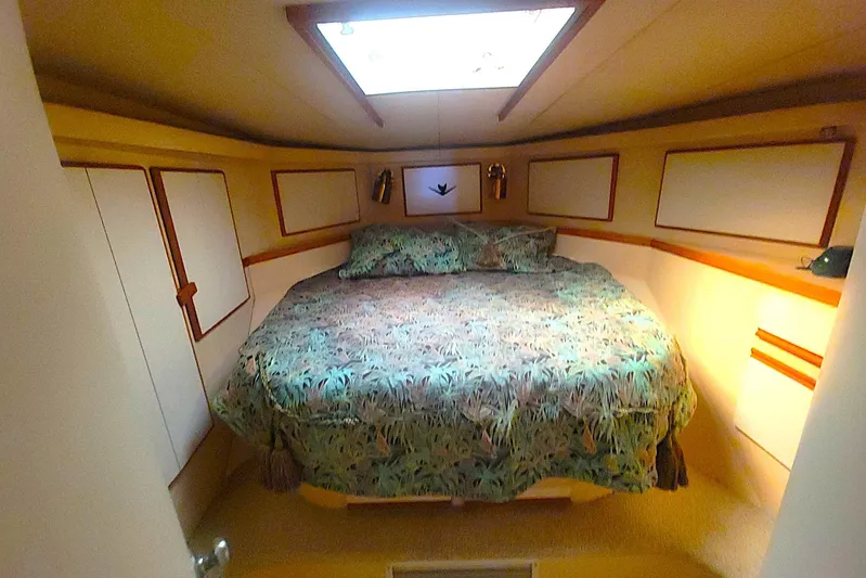Trophy Hunter Yacht Photos Pics Cozy bedroom in 1989 Bertram 50 Convertible yacht with floral bedding and skylight.