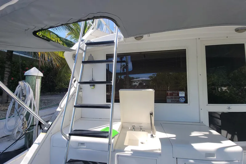 Trophy Hunter Yacht Photos Pics 1989 Bertram 50 Convertible yacht with ladder and outdoor sink, docked under canopy.