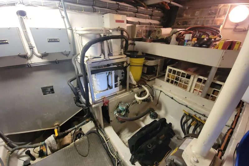 Trophy Hunter Yacht Photos Pics Engine room of a 1989 Bertram 50 Convertible boat, showcasing mechanical components and storage.