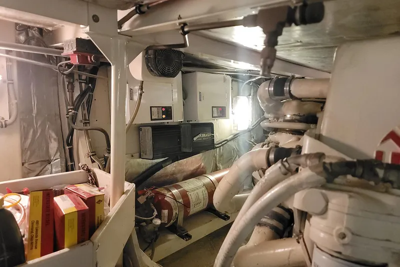 Trophy Hunter Yacht Photos Pics Engine room of 1989 Bertram 50 Convertible yacht with mechanical components and fire extinguisher.
