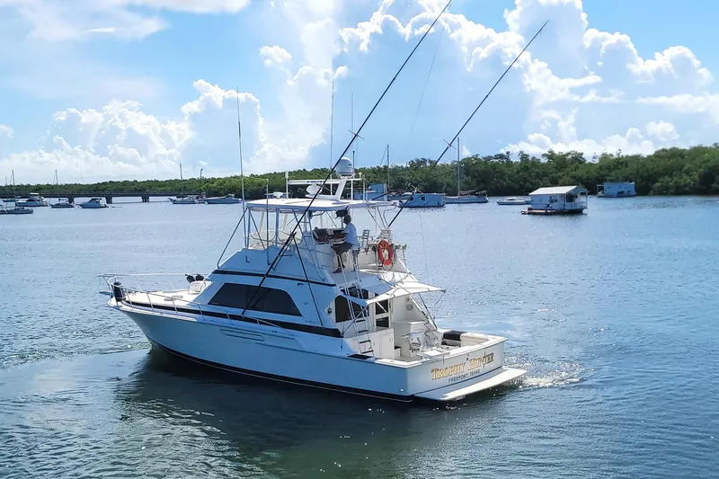 Trophy Hunter Yacht Photos Pics 1989 Bertram 50 Convertible yacht cruising on a sunny day with blue skies.