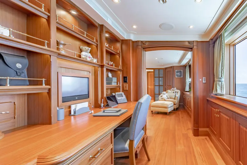 Shadowl Yacht Photos Pics Luxurious yacht interior with wooden desk, shelves, and ocean view window.
