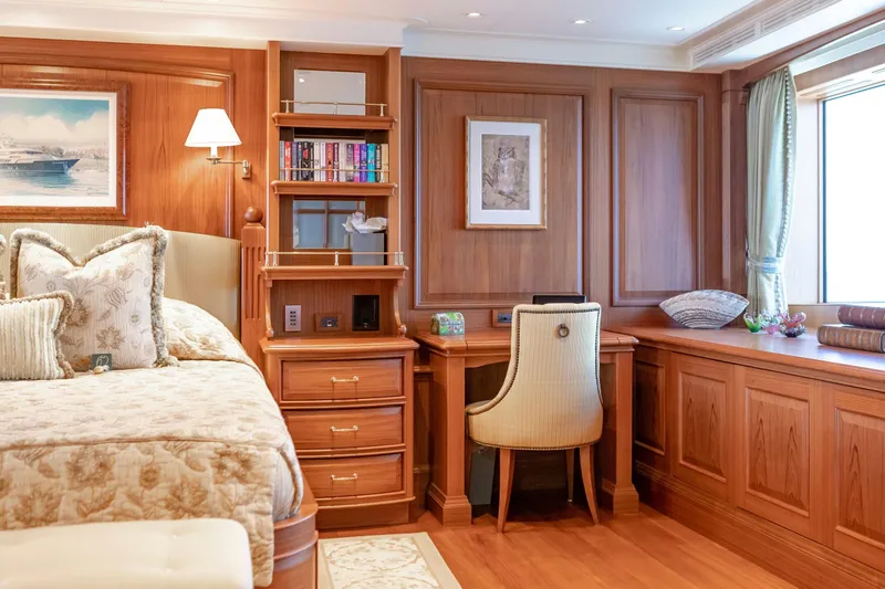 Shadowl Yacht Photos Pics Luxurious yacht bedroom with wooden decor, cozy bed, and elegant desk area.