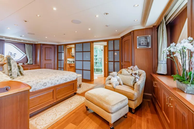 Shadowl Yacht Photos Pics Luxurious yacht bedroom with elegant wood paneling and plush furnishings, featuring a cozy seating area.