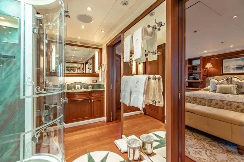 Shadowl Yacht Photos Pics Luxurious yacht interior with elegant bathroom and cozy bedroom, featuring wood accents and plush decor.
