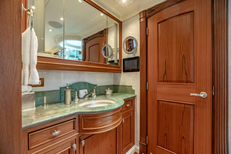Shadowl Yacht Photos Pics Luxurious yacht bathroom with wooden cabinetry, green marble countertop, and elegant fixtures.