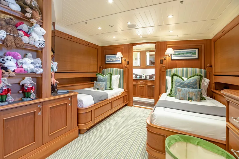 Shadowl Yacht Photos Pics Luxurious yacht bedroom with twin beds, wooden decor, and plush toys on shelves.