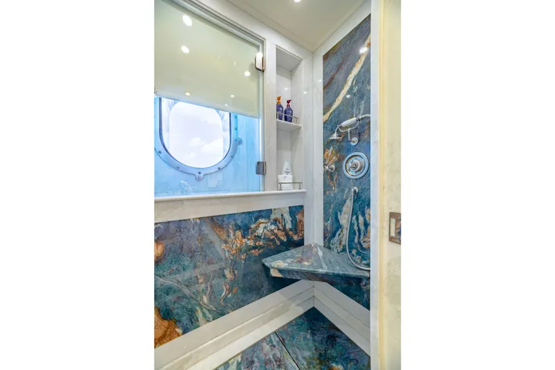 Shadowl Yacht Photos Pics Luxurious yacht shower with marble design, porthole window, and modern fixtures.