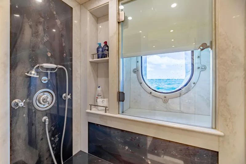 Shadowl Yacht Photos Pics Luxurious yacht shower with ocean view through porthole, featuring modern fixtures and toiletries.