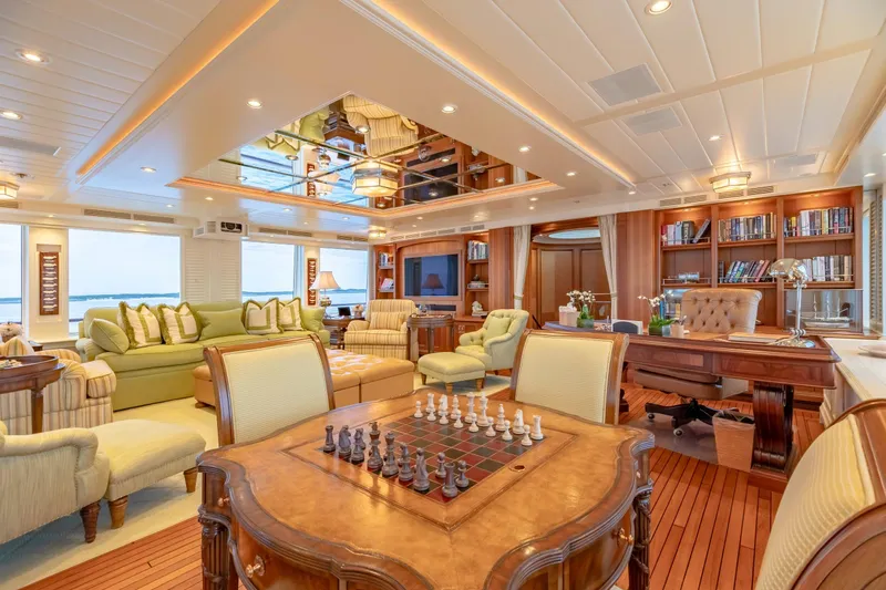 Shadowl Yacht Photos Pics Luxurious yacht interior with elegant furnishings, chess set, and bookshelves, Burger Custom 2010 model.