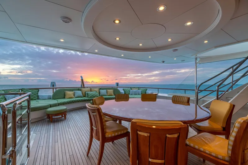 Shadowl Yacht Photos Pics Luxurious yacht deck with sunset view, featuring elegant seating and dining area.