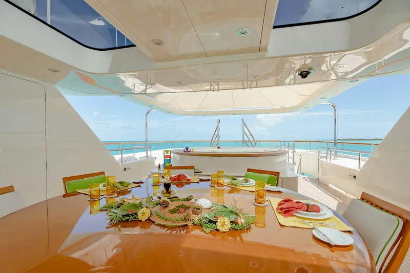 Shadowl Yacht Photos Pics Luxurious yacht dining area with ocean view, featuring elegant table setting and tropical decor.
