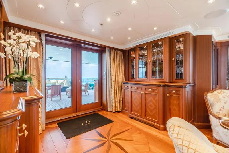 Shadowl Yacht Photos Pics Luxurious yacht interior with elegant wood cabinetry and glass doors, featuring a scenic ocean view.