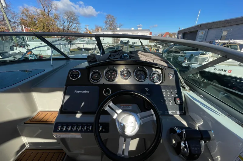  Yacht Photos Pics 2016 Sea Ray 310 Sundancer dashboard with steering wheel and gauges under clear blue sky.
